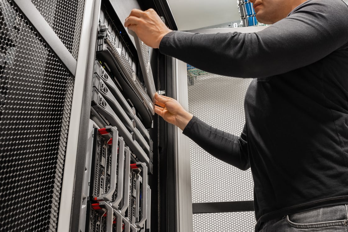 Male IT Technician Installing Drive In Rack